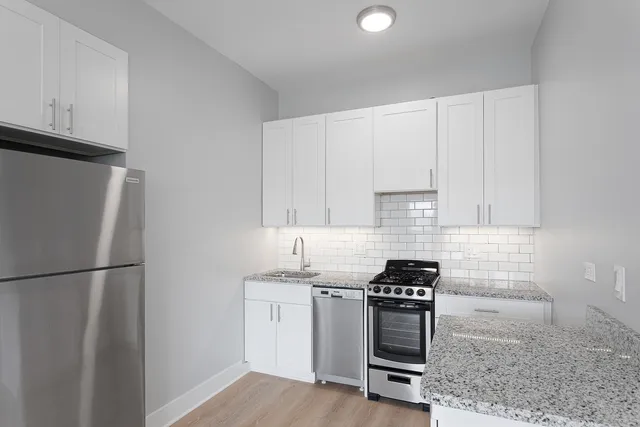 a kitchen with a refrigerator stove and cabinets