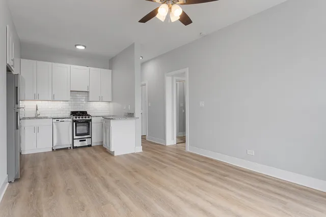 a kitchen with granite countertop white cabinets and stainless steel appliances