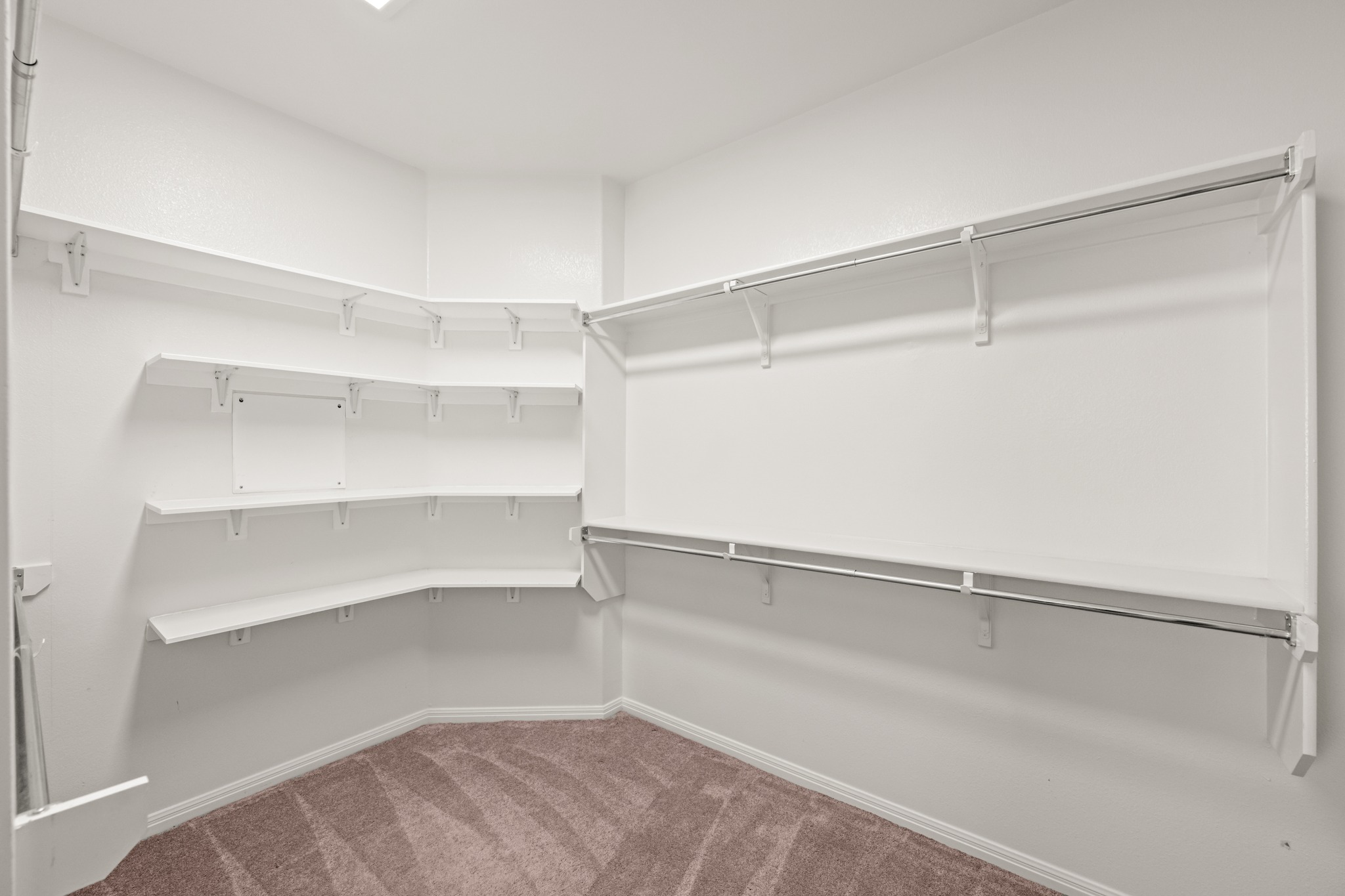 1023 Grassy Field Road Austin, TX 78737 - Photo 20 of 40 Primary walk-in closet featuring built-in shelving, chrome hanging rods, and neutral carpet flooring