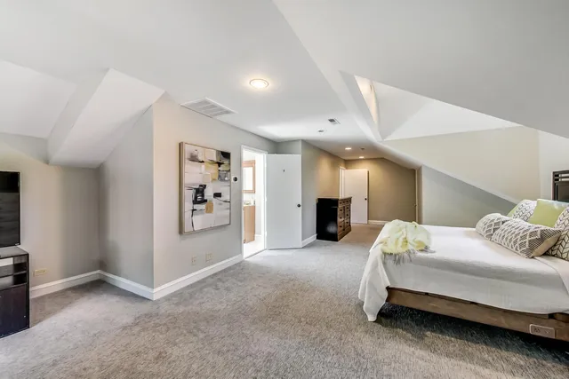 a spacious bedroom with a bed and a refrigerator