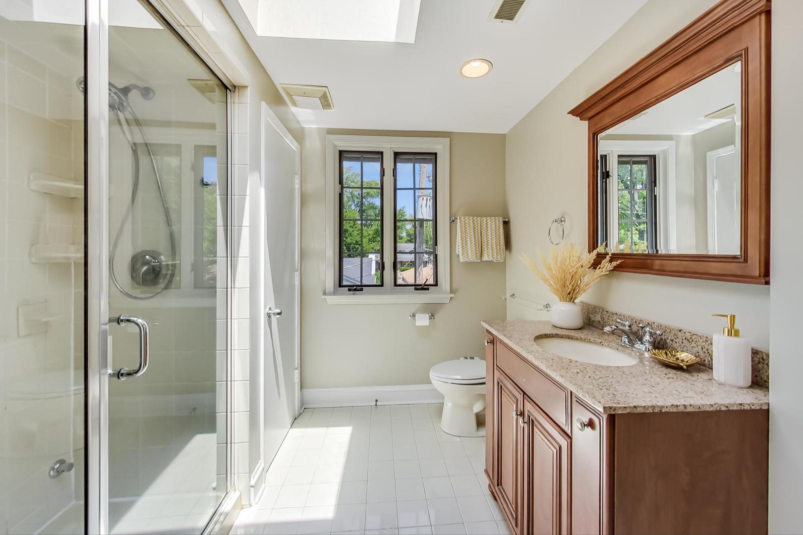 504 Illinois Road Wilmette, IL 60091 - Photo 23 of 43 a bathroom with a granite countertop sink toilet and shower