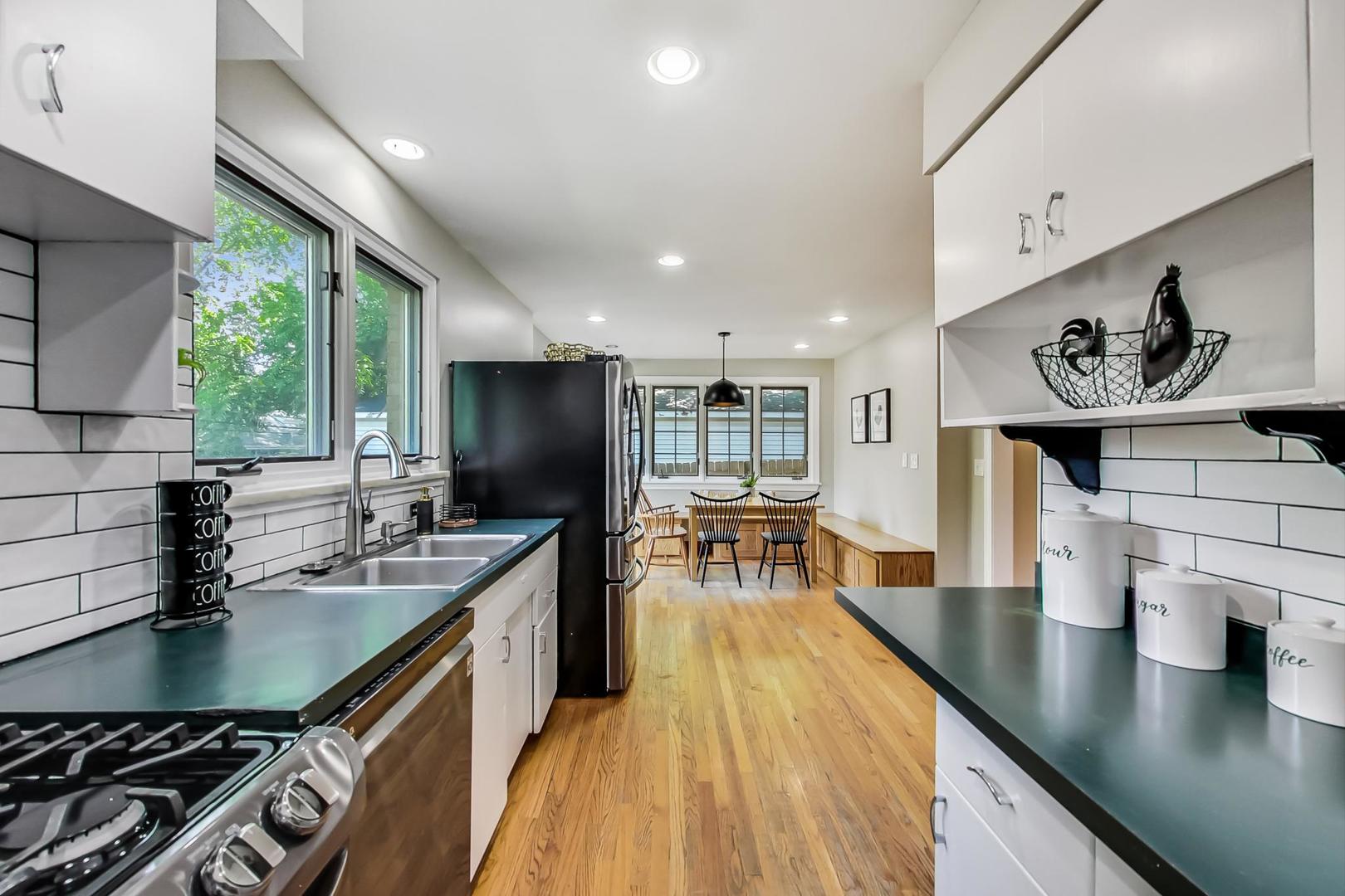 504 Illinois Road Wilmette, IL 60091 - Photo 9 of 43 a kitchen with stainless steel appliances granite countertop sink stove and wooden floor