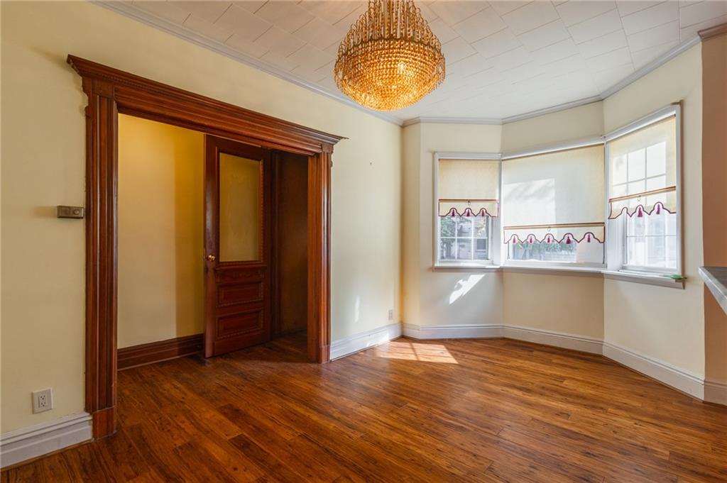 231 Monitor Street Brooklyn, NY 11222 - Photo 13 of 37 an empty room with wooden floor and chandelier