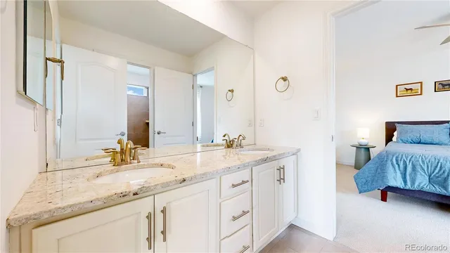 a en suite bathroom with a granite countertop sink and a mirror