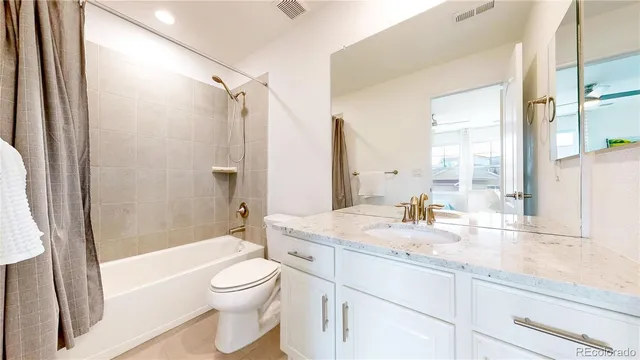 a bathroom with a granite countertop sink toilet a large mirror a bathtub and next to a window