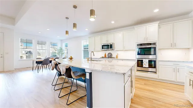 a kitchen with stainless steel appliances kitchen island granite countertop a refrigerator and microwave