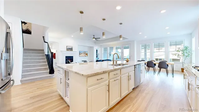 a large white kitchen with lots of counter space and stainless steel appliances