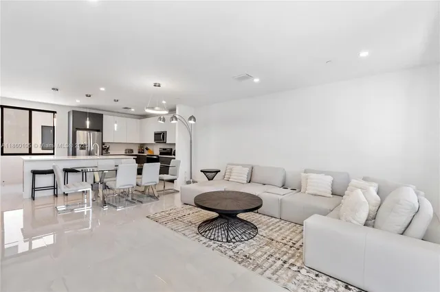 a living room with furniture and view of kitchen