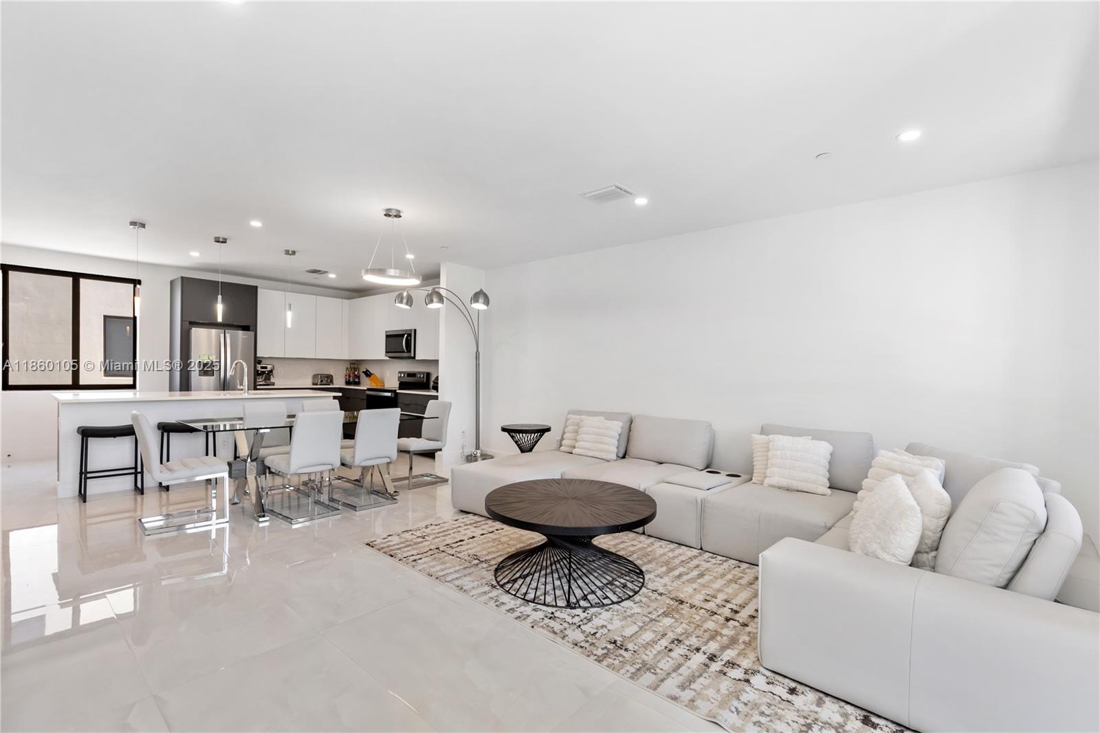 a living room with furniture and view of kitchen