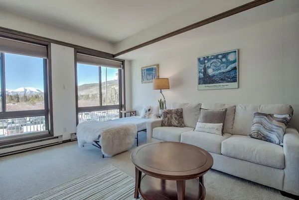 a living room with furniture and a floor to ceiling window