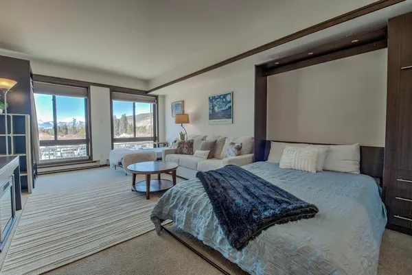 a spacious bedroom with a large bed and a wooden floor