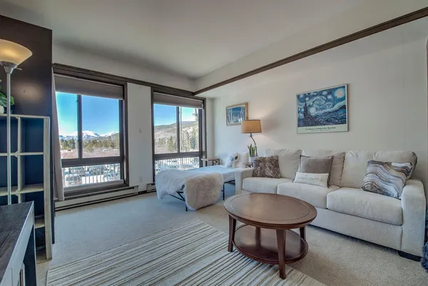 a living room with furniture and a floor to ceiling window