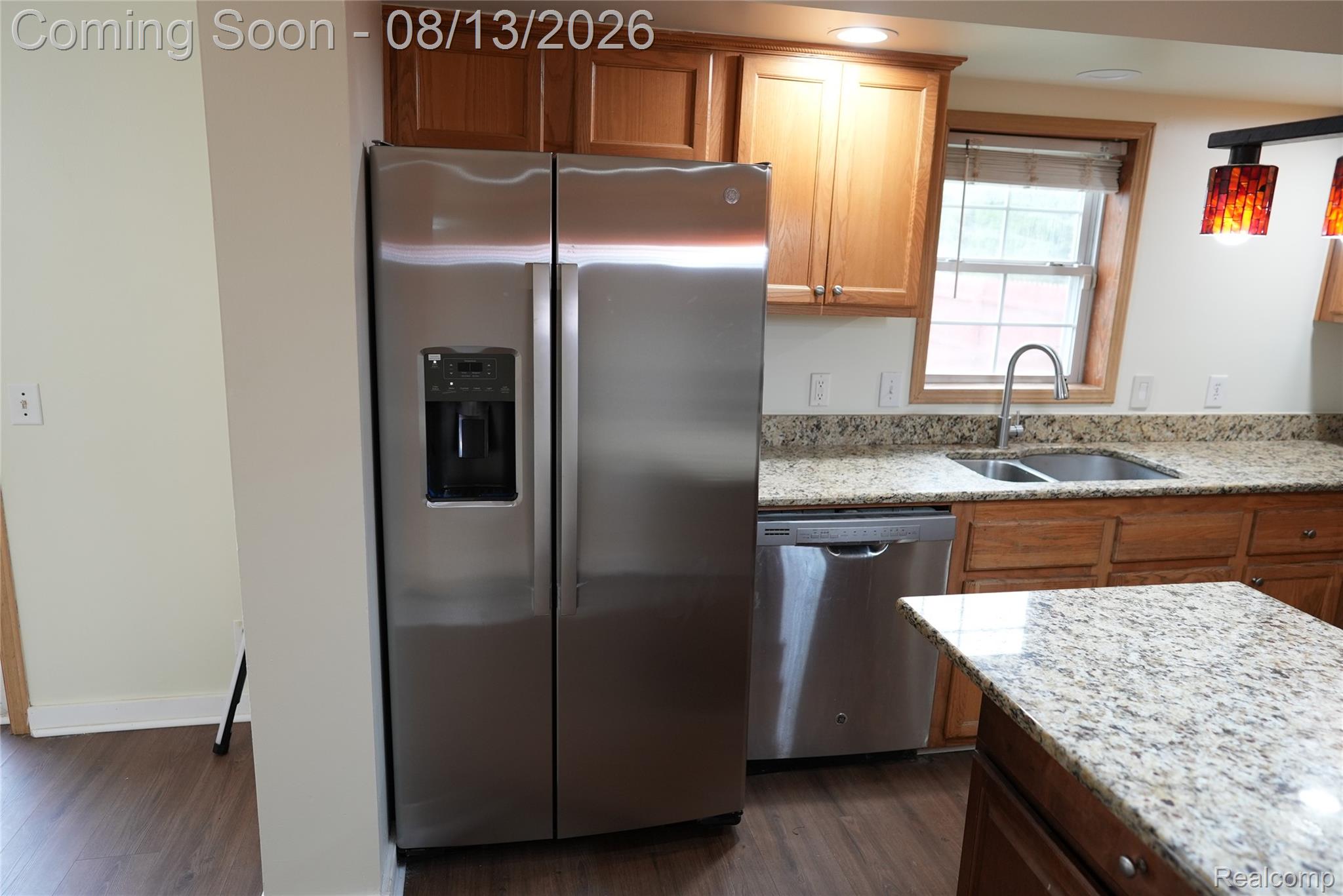 2018 John R Road Troy, MI 48083 - Photo 17 of 57 Stainless steel side-by-side refrigerator, stainless steel dishwasher, double basin sink with gooseneck faucet, light granite countertops, and wood-finish flooring