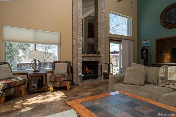 a living room with furniture a fireplace and a large window