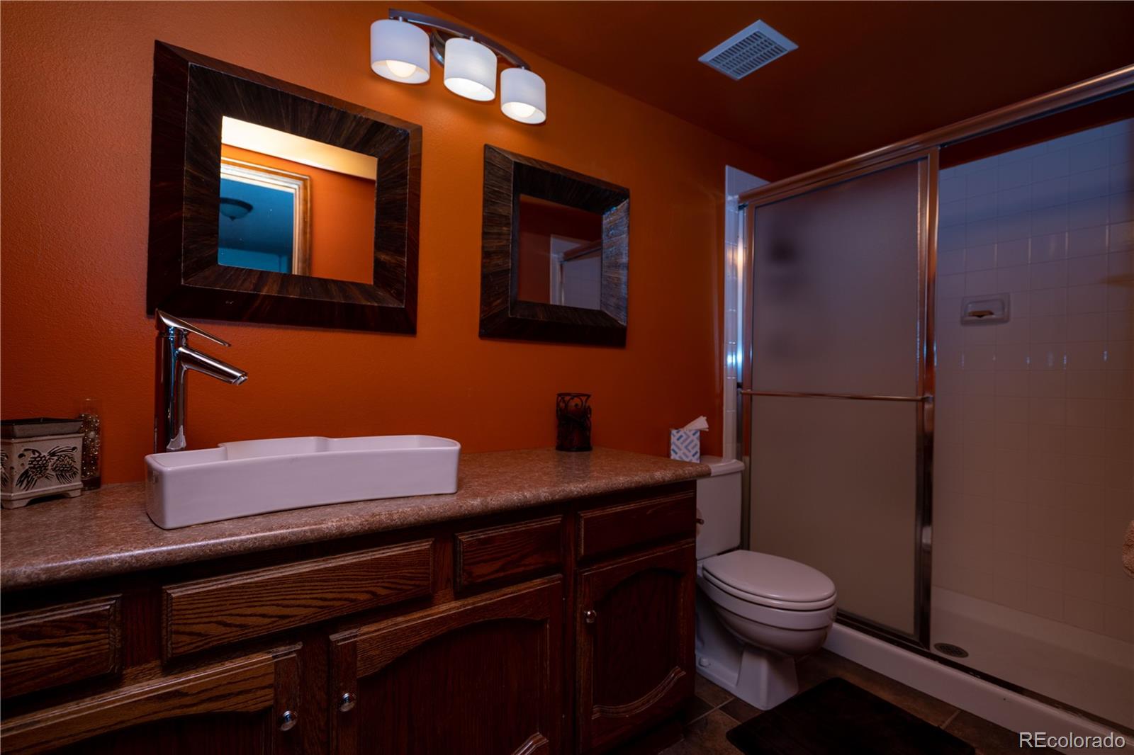 8583 Redstone Street Highlands Ranch, CO 80126 - Photo 14 of 17 a bathroom with a toilet a sink and mirror