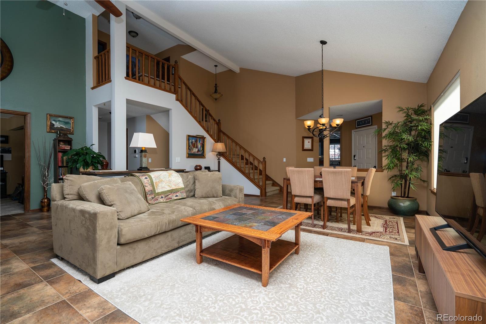 8583 Redstone Street Highlands Ranch, CO 80126 - Photo 2 of 17 a living room with furniture ceiling fan and a rug
