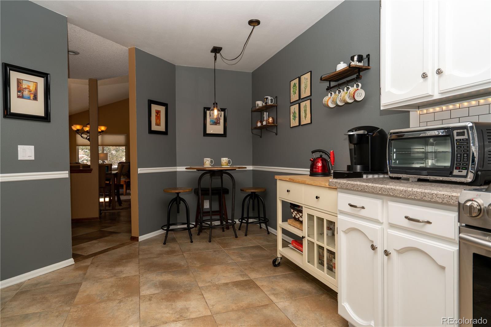 8583 Redstone Street Highlands Ranch, CO 80126 - Photo 10 of 17 a kitchen with cabinets and chairs in it
