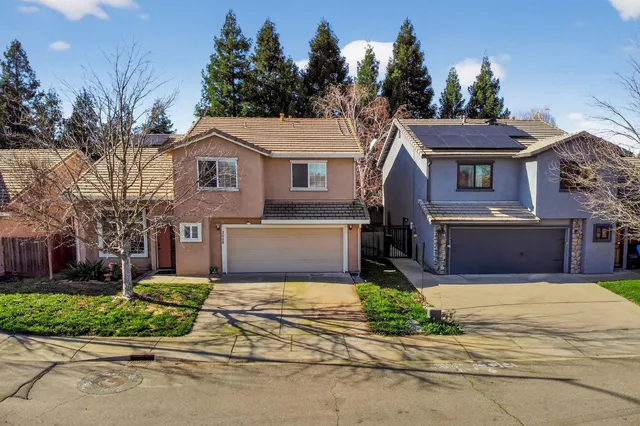 a front view of a house with a yard and potted plants