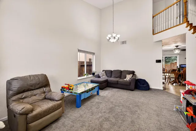 a kitchen with granite countertop a refrigerator a stove top oven a sink and cabinets