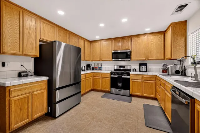 a kitchen with stainless steel appliances granite countertop a stove a sink and a microwave