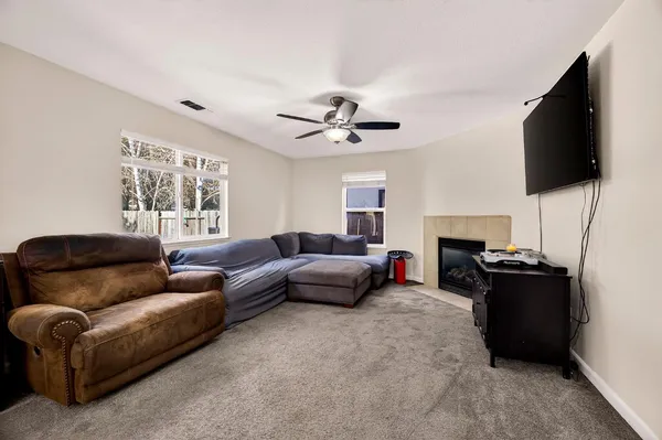 a living room with furniture a flat screen tv and a fireplace