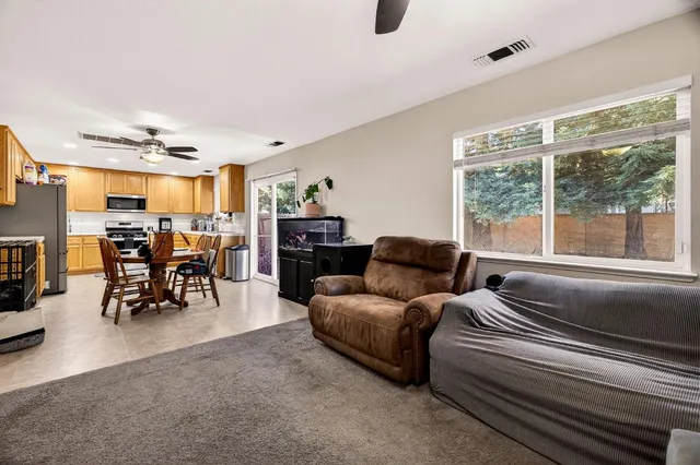 a living room with furniture a flat screen tv and a large window