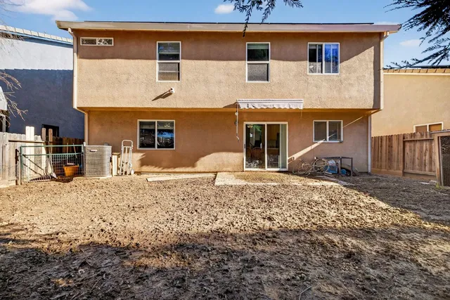 a view of a backyard with large trees and wooden fence