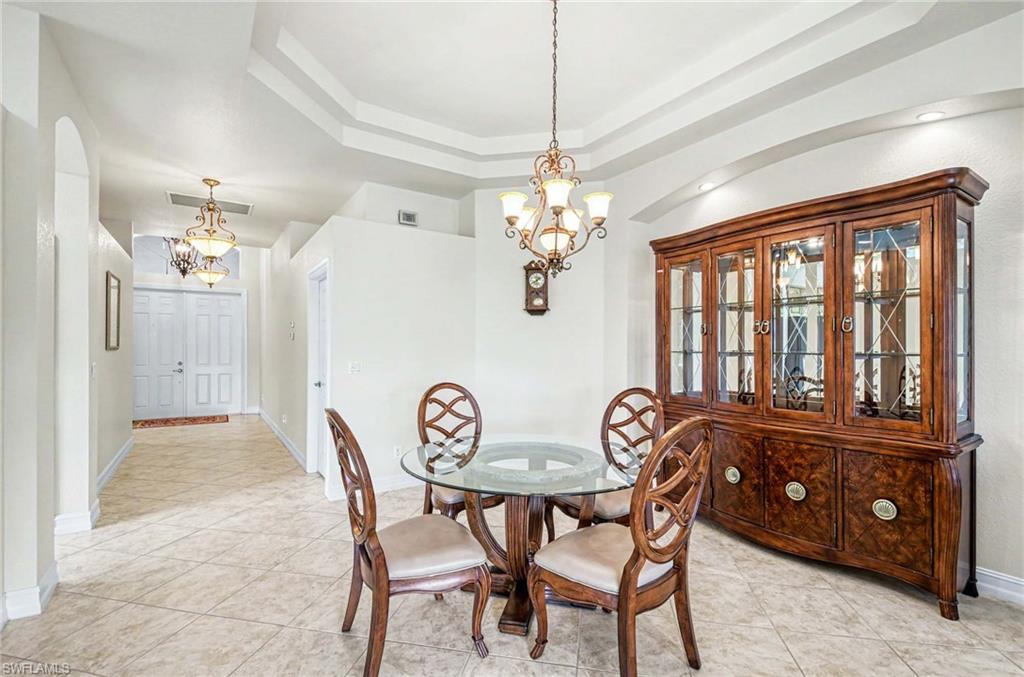 14809 Canton Court Naples, FL 34114 - Photo 11 of 43 a view of a dining room with furniture large windows and a chandelier