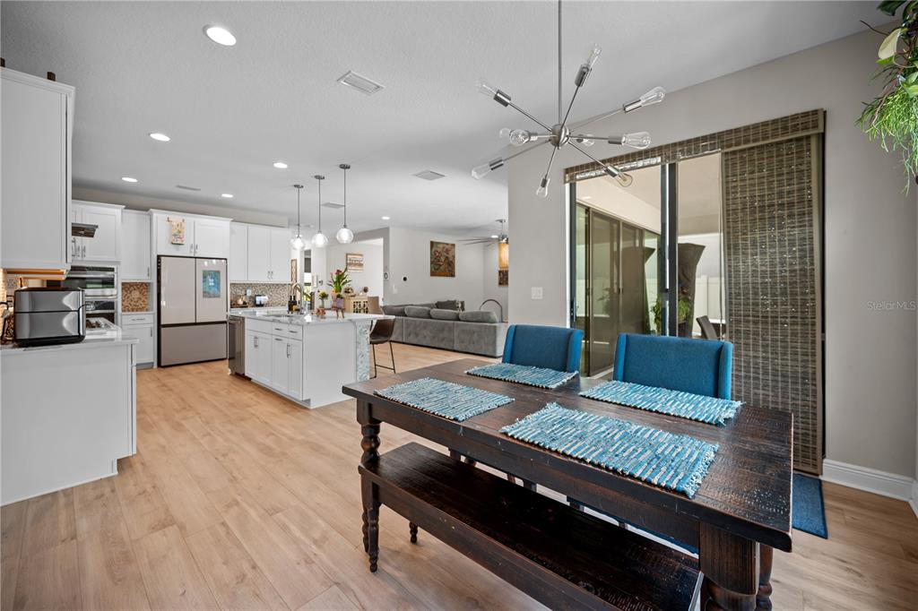 14734 Horse Trot Road Lithia, FL 33547 - Photo 12 of 66 a living room with stainless steel appliances kitchen island granite countertop furniture and a wooden floor