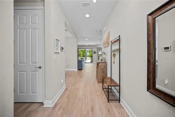 a view of a hallway view with wooden floor and living room