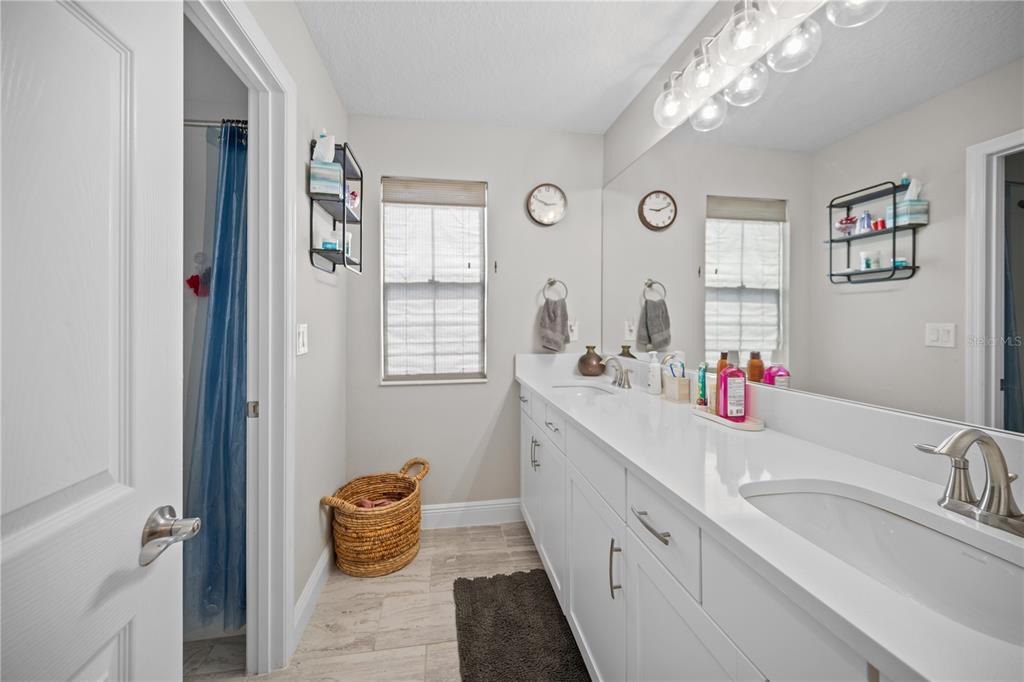 14734 Horse Trot Road Lithia, FL 33547 - Photo 49 of 66 a bathroom with double vanity sinks a mirror and a shower