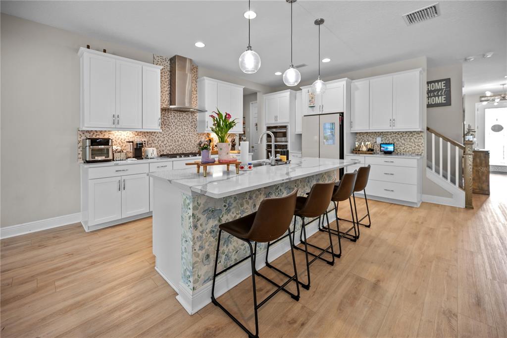 14734 Horse Trot Road Lithia, FL 33547 - Photo 7 of 66 a kitchen with stainless steel appliances kitchen island granite countertop a table chairs refrigerator and microwave