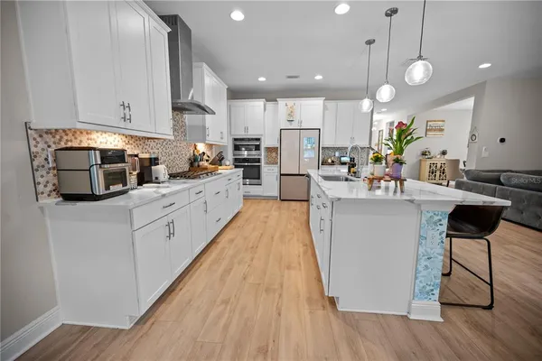 a kitchen with stainless steel appliances white cabinets and a refrigerator