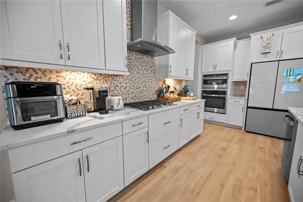 a living room with stainless steel appliances kitchen island granite countertop furniture and a wooden floor