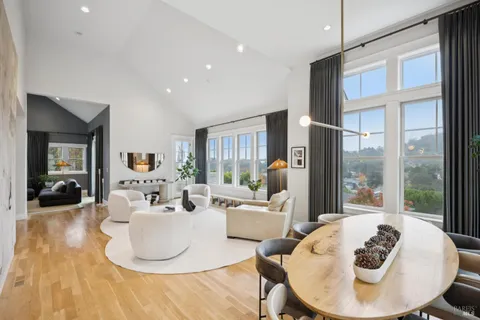 a view of a dining room with furniture a kitchen and chandelier