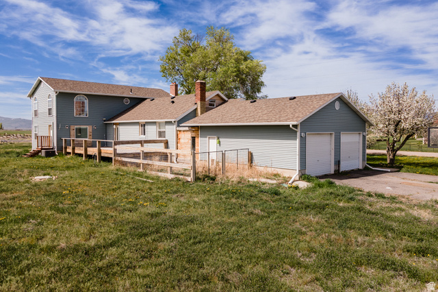 19994 South Olson Road Downey, ID 83234 - Photo 32 of 49 Rear view of property featuring an outbuilding, a deck, roof with shingles, and a garage