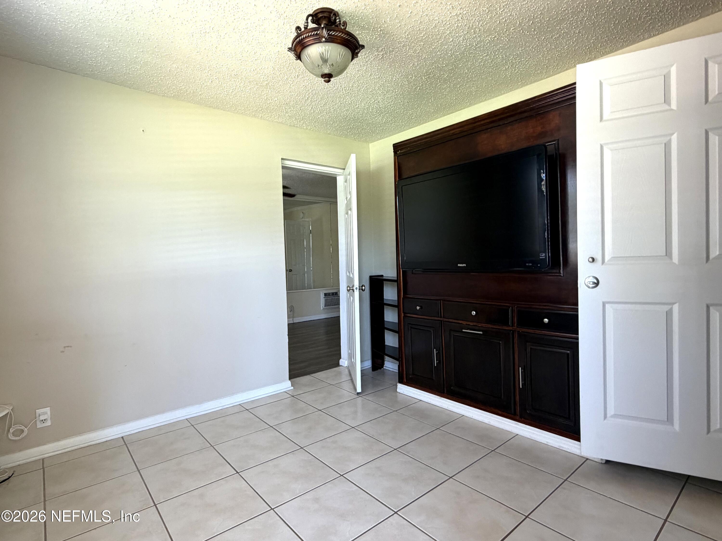 4127 Springwood Road Jacksonville, FL 32207 - Photo 16 of 63 a living room with a flat screen tv and a walk in closet
