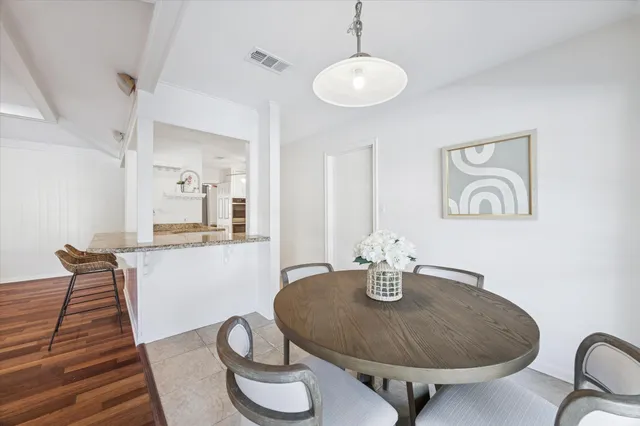 a dining room with table chairs and a chandelier