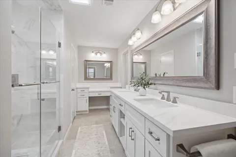 a spacious bathroom with a double vanity sink mirror and shower