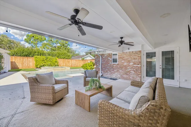 a living room with patio furniture and a large window