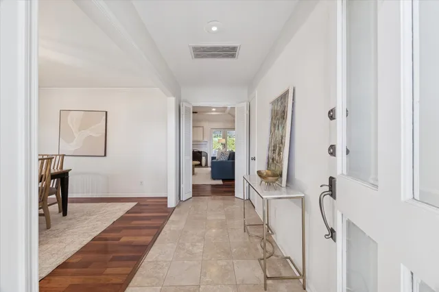 a view of a hallway with wooden floor and a living room