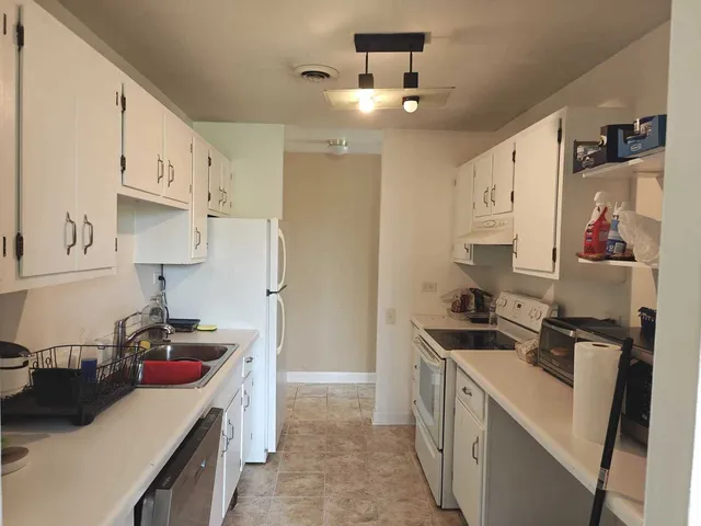 a kitchen that has a lot of cabinets in it and wooden floors