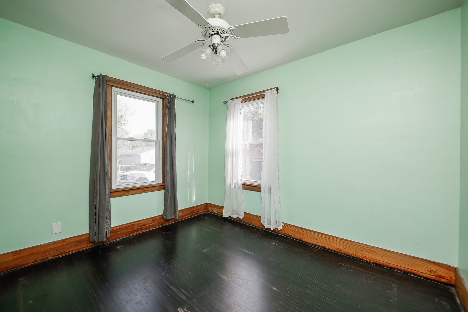 10N835 Rippburger Road Elgin, IL 60124 - Photo 14 of 20 an empty room with wooden floor and windows with curtains