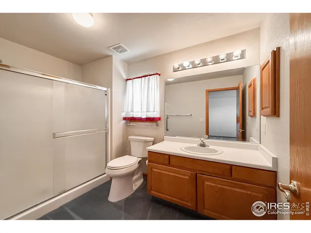a bathroom with a sink vanity mirror and toilet
