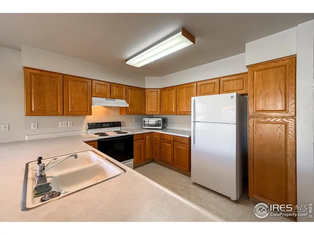 a kitchen with a refrigerator sink and cabinets