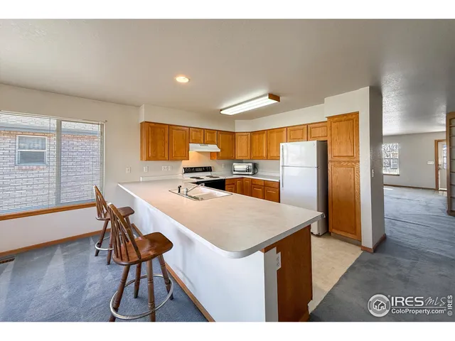 a kitchen with stainless steel appliances kitchen island a table and chairs in it