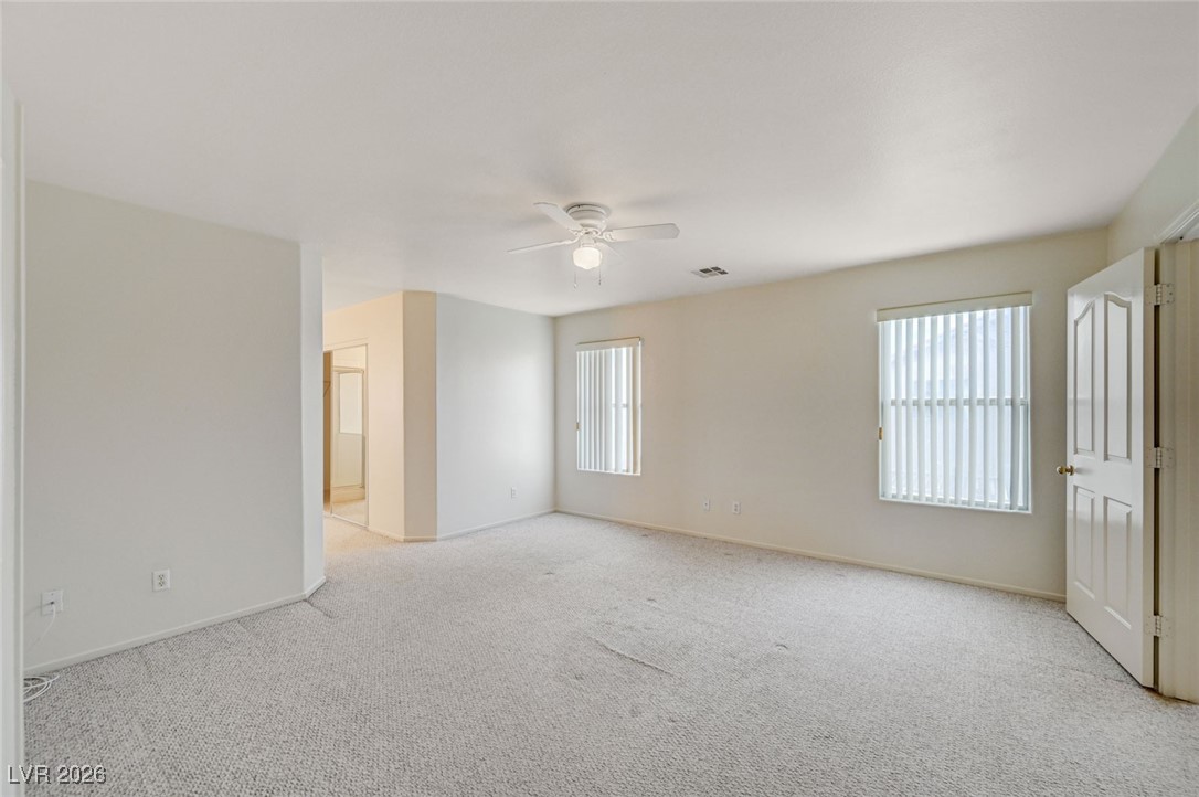 3901 Triora Street Las Vegas, NV 89129 - Photo 21 of 42 Empty room with healthy amount of natural light, light colored carpet, and a ceiling fan