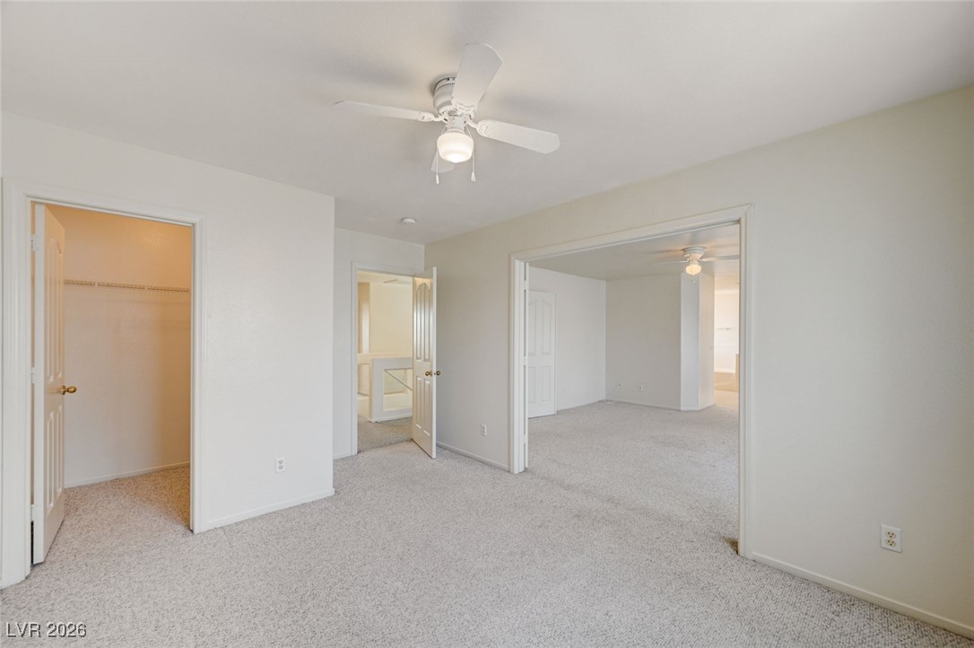 3901 Triora Street Las Vegas, NV 89129 - Photo 26 of 42 Unfurnished bedroom with a spacious closet, light carpet, and ceiling fan