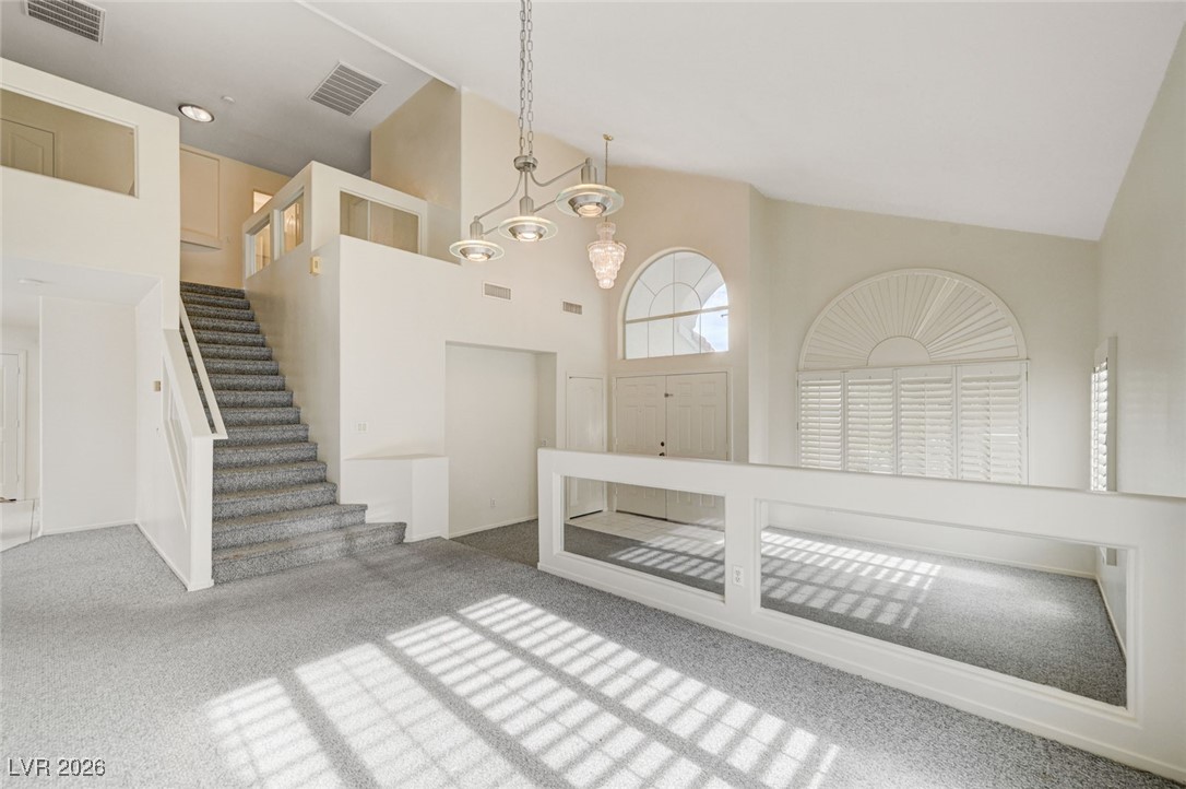 3901 Triora Street Las Vegas, NV 89129 - Photo 3 of 42 Entrance foyer featuring high vaulted ceiling, carpet, and stairway
