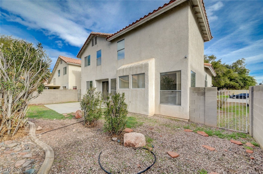 3901 Triora Street Las Vegas, NV 89129 - Photo 39 of 42 Back of property featuring a tile roof, stucco siding, a fenced backyard, and a patio area